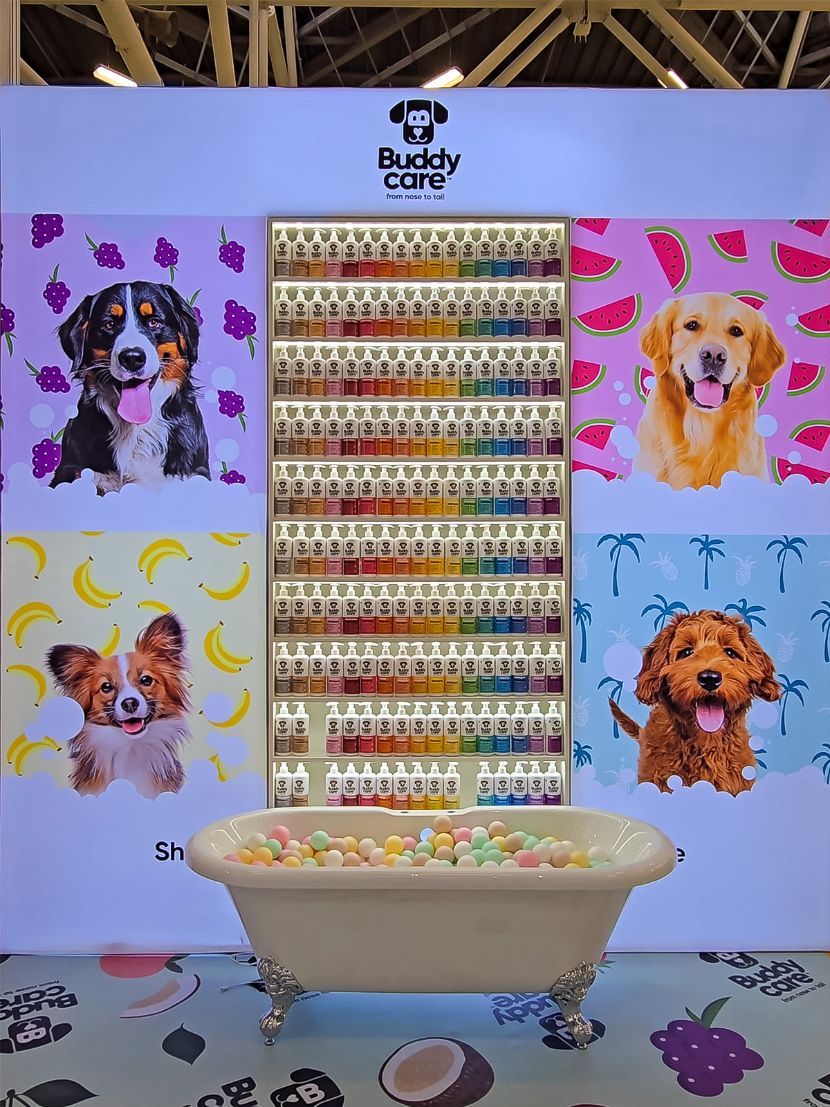 Recessed shelving integrated into a modular exhibition stand wall, displaying colourful product bottles illuminated with LED lighting at a trade show.